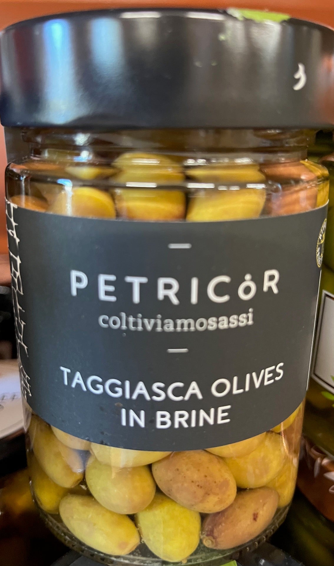 Jar of Petricor Taggiasca Olives in Brine with a black label.